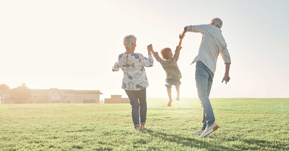 older woman and man with little kid in field